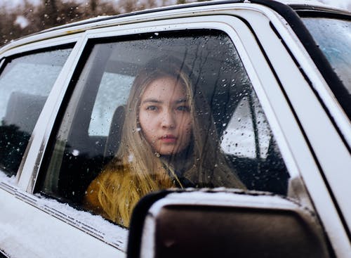 沉思妇女坐在有下落的汽车在窗口 · 免费素材图片