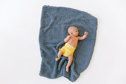 睡觉在蓝色格子花呢披肩的可爱的新出生的婴孩的充分的身体在演播室 · 免费素材图片