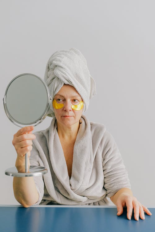 看镜子里的眼罩的老年的女人 · 免费素材图片