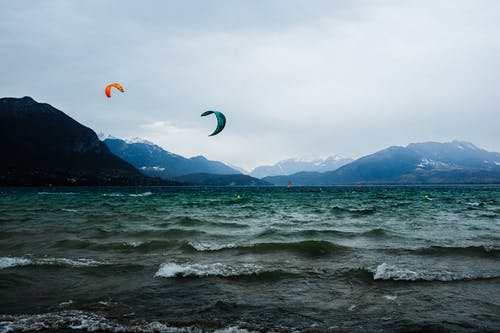 壮观的山脉后面的波浪海洋和晚上的降落伞 · 免费素材图片