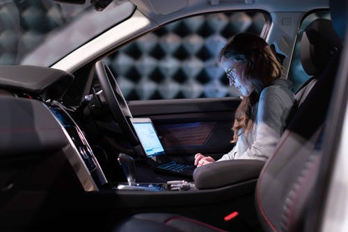 在汽车内使用笔记本电脑的女工程师 · 免费素材图片