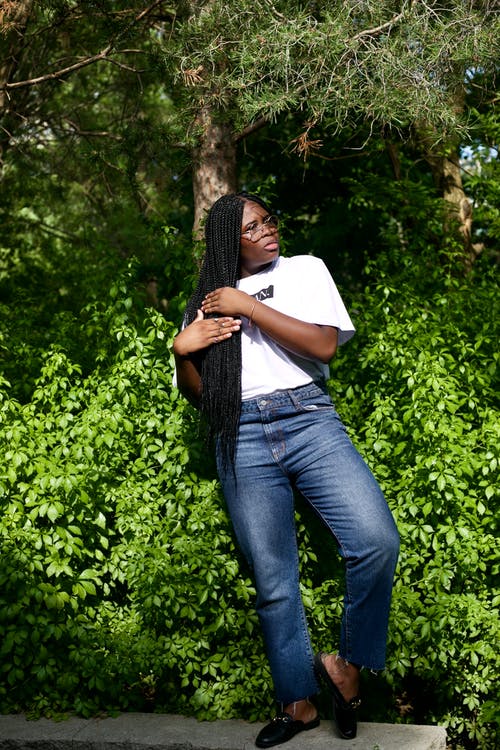 站立在庭院里的轻松的年轻黑人妇女在晴天 · 免费素材图片