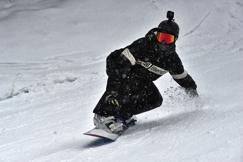 黑夹克和黑裤子骑在滑雪板上的人 · 免费素材图片
