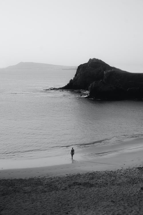 在海滩上行走的人的灰度照片 · 免费素材图片