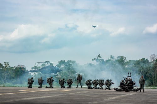 无法识别的士兵用步兵武器完成直升机附近的军事任务 · 免费素材图片