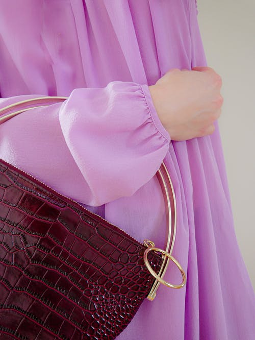 拿着棕色皮包的粉红色衬衫的人 · 免费素材图片