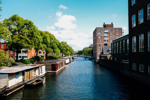 宁静的市区，现代建筑与流运河在阳光灿烂的日子 · 免费素材图片