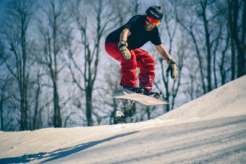 男子骑在半空中的滑雪板上 · 免费素材图片