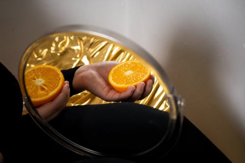 持有橙色柑橘类水果的人 · 免费素材图片
