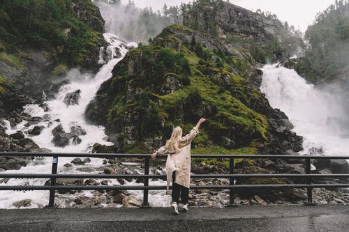 不可识别的女游客享受山中瀑布的景色 · 免费素材图片