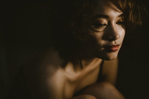 女人在黑暗的房间里的特写照片 · 免费素材图片