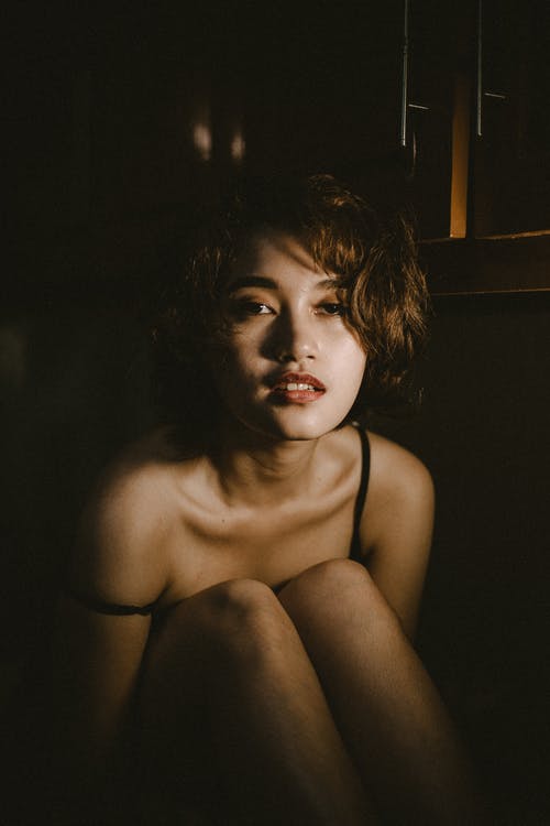 在一个黑暗的房间里的女人的照片 · 免费素材图片