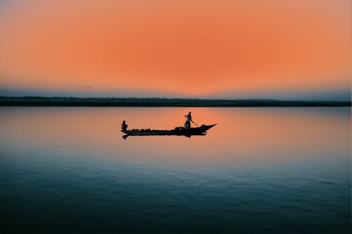在日落期间骑在船上的人 · 免费素材图片