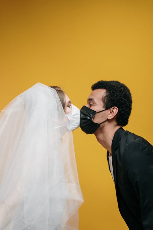 黑色西装的男人亲吻白色面纱的女人 · 免费素材图片