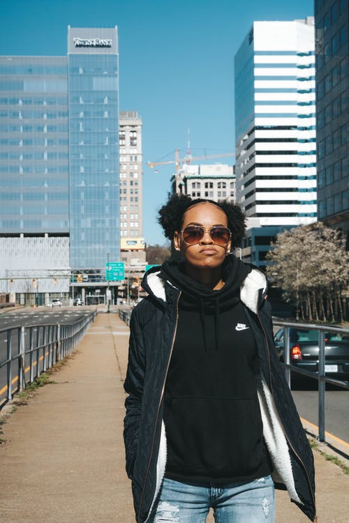 黑色连帽衫站在人行道上的女人 · 免费素材图片