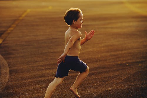 黑色短裤的裸照男孩在棕色领域上运行 · 免费素材图片