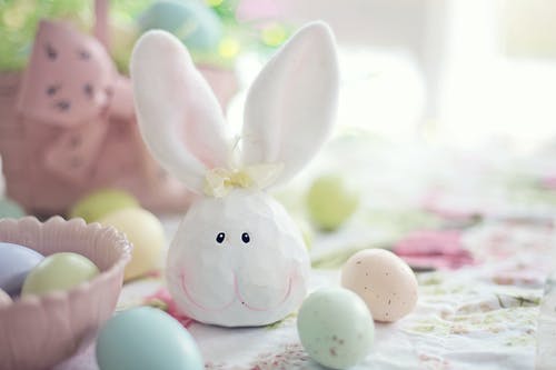 白色和粉红色的花纺织上的白兔子雕像 · 免费素材图片
