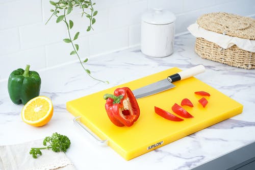 红辣椒在黄色砧板上 · 免费素材图片