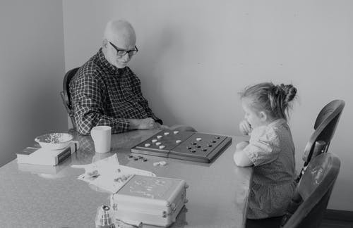 男人和小女孩玩跳棋 · 免费素材图片