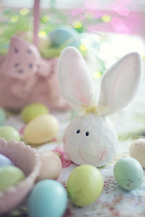 复活节彩蛋旁边的白兔子雕像 · 免费素材图片