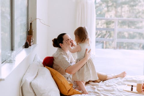 母亲和女儿在卧室里玩，而在家里一起度过时光 · 免费素材图片