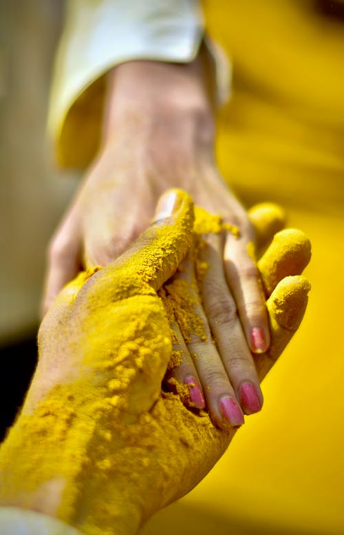 人的手覆盖着黄色粉末 · 免费素材图片