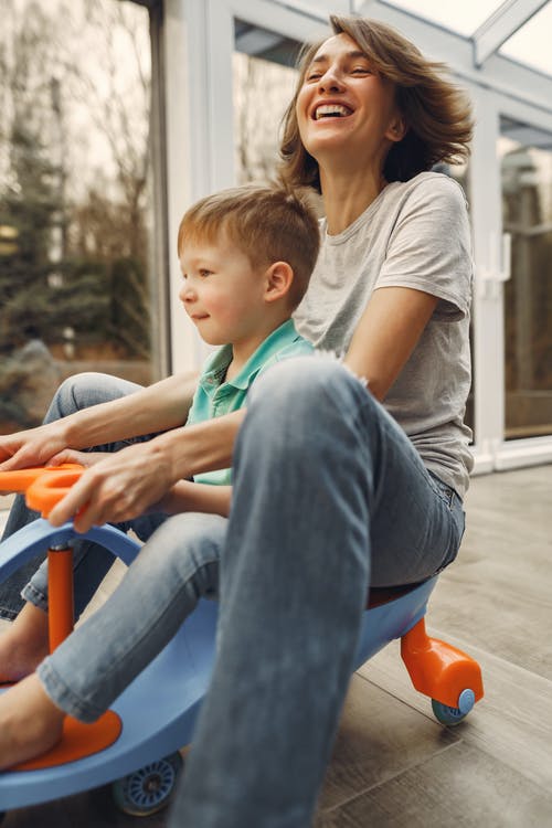 母亲和儿子骑扭扭车 · 免费素材图片