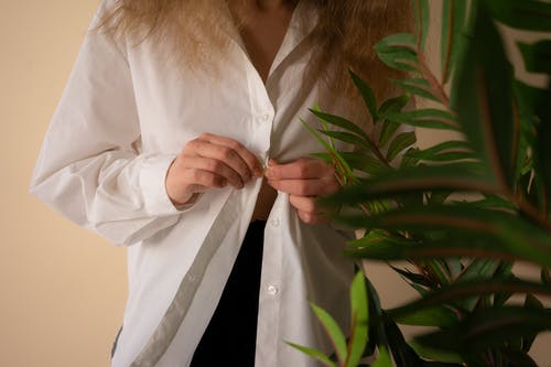绿色植物附近的长袖衬衫的白色按钮的女人 · 免费素材图片