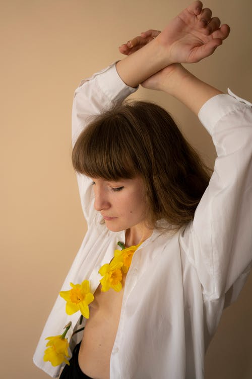 拿着黄色花的白色礼服衬衣的妇女 · 免费素材图片