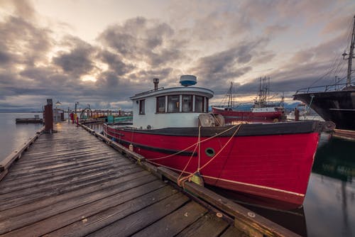 红色和白色的小船在码头上多云的天空下 · 免费素材图片
