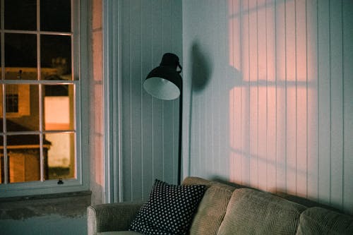 灰色的沙发旁边的黑色落地灯 · 免费素材图片