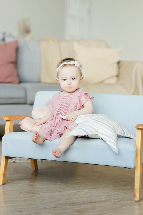 坐在沙发上的粉红色裙子的宝贝女儿 · 免费素材图片