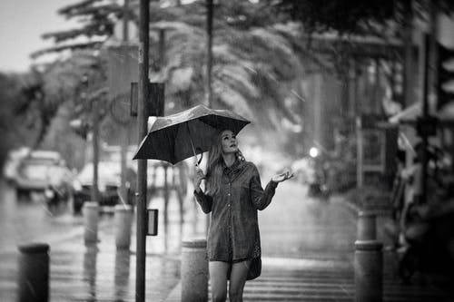 女人拿着伞的灰度照片 · 免费素材图片