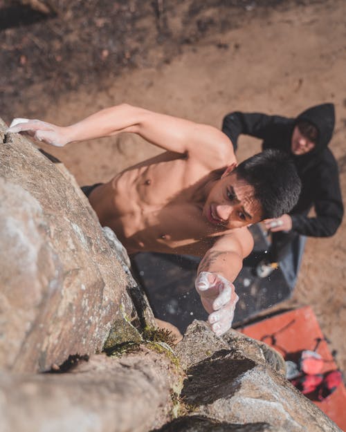 在锻炼过程中坚强的年轻登山者从石质悬崖上掉下来 · 免费素材图片