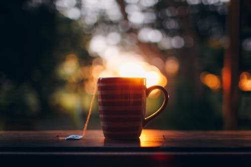 杯热茶在日落期间的木制窗台上 · 免费素材图片