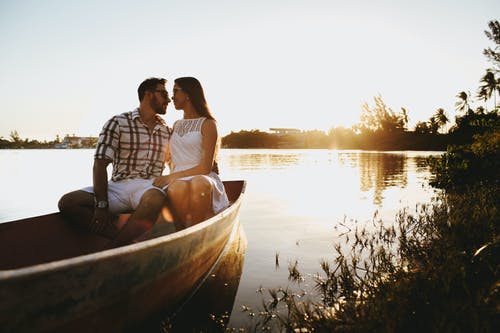 年轻夫妇一起度过时间在漂浮在湖上的木船上 · 免费素材图片