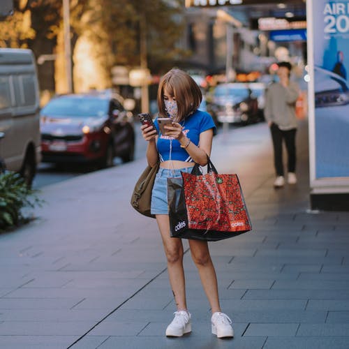女人抱着两个智能手机忙发短信 · 免费素材图片