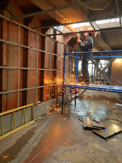 焊工在工业建筑内工作 · 免费素材图片