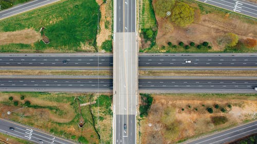 郊区绿树附近的道路连接 · 免费素材图片