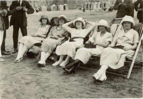 妇女坐在折叠椅上的灰度照片 · 免费素材图片