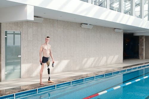 假腿站在游泳池旁的男人 · 免费素材图片