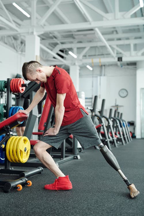 红衬衫伸展的男人的照片 · 免费素材图片