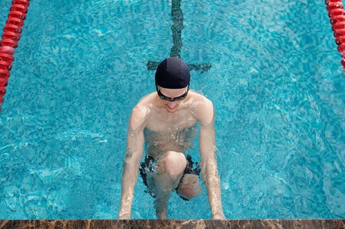 黑色短裤的人在游泳池里游泳 · 免费素材图片