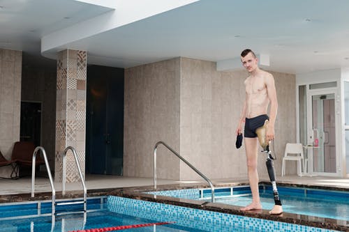 黑色短裤站在游泳池上的男人 · 免费素材图片