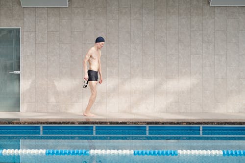 黑色短裤站在游泳池上的男人 · 免费素材图片