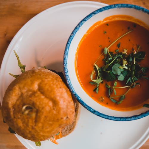 脆皮汉堡包和咖啡馆里明亮的番茄汤 · 免费素材图片