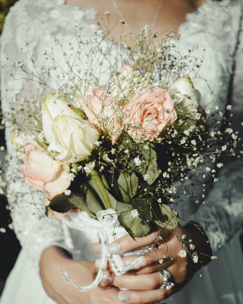 不露面新娘与婚礼当天的鲜花花束 · 免费素材图片