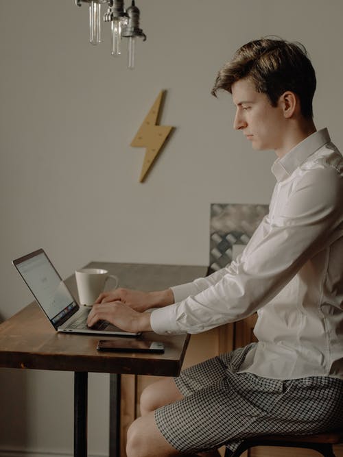 使用黑色便携式计算机的白衬衫的男人 · 免费素材图片