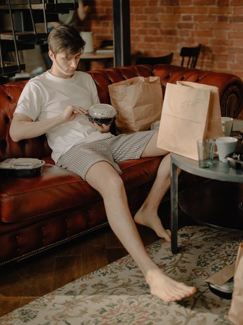 白衬衫和黑色和白色裙子坐在棕色皮革沙发上的女人 · 免费素材图片