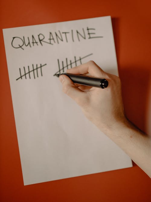 拿着黑笔写在白纸上的人 · 免费素材图片